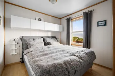 a bedroom with a large bed and a window at Lovely apartment with amazing view and sauna in Skulestadmo