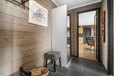 a home hallway with wood paneling and a stool at Lovely apartment with amazing view and sauna in Skulestadmo
