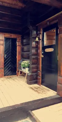 a porch of a wooden house with a door and a plant at Siribu in Vågsli