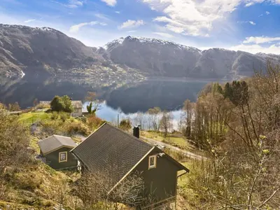 a house with a view of a lake and mountains at Peaceful Cabin With Spa On Osterøy in Bruvik