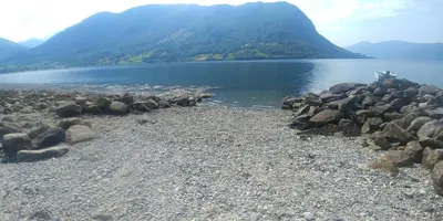 a large group of rocks on the shore of a lake at Flott hytte i Vistdal, Romsdal in Myklebostad
