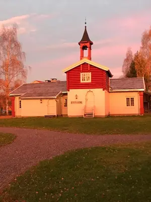 a red and white barn with a tower at Stor-Elvdal Hotell in Koppang