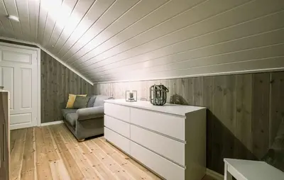 a room with a couch and a dresser in a attic at Family Cabin With Ski Inout In Rauland in Rauland