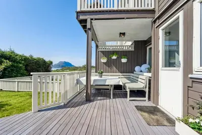 a patio with a table and chairs on a deck at Moderne rekkehus nært Ålesund in Valderøya