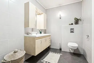 a white bathroom with a sink and a toilet at Moderne rekkehus nært Ålesund in Valderøya
