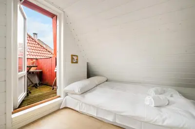 a bed in a room with a window at Scandinavian Hideaway I Private Balcony in Bergen