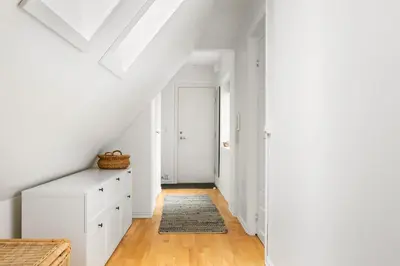 an attic bedroom with white walls and a white dresser at Scandinavian Hideaway I Private Balcony in Bergen
