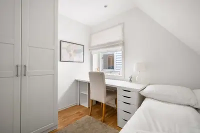 a white bedroom with a desk and a bed at Scandinavian Hideaway I Private Balcony in Bergen