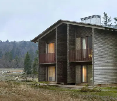 a wooden house with a balcony in a field at Architect Designed Mountain Cabin At Kvitfjell in Favang