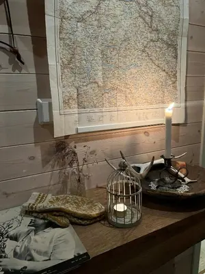 a table with a candle and a map on a wall at Charming Cabin In Jotunheimen in Vaga