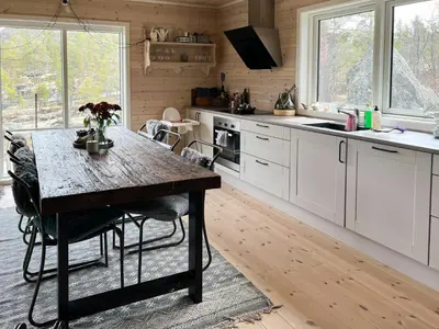 a kitchen with white cabinets and a wooden table at Charming Cabin In Jotunheimen in Vaga