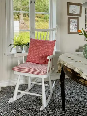 a white rocking chair in a room with a window at Peaceful Log Cabin By The Fjord On Ytterøy in Ytteroy