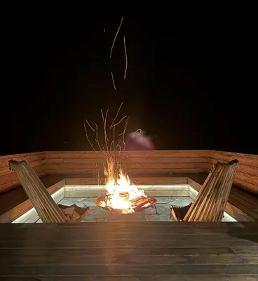 two chairs sitting next to a fire in a hot tub at Mountain Cabin With Panoramic Views In Savalen in Tynset