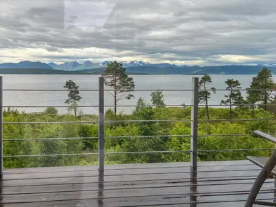 a balcony with a view of the water and mountains at Architect-Designed Cabin With View In Molde in Røvik