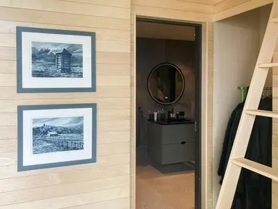 a hallway with pictures on the wall and a mirror at Architect-Designed Cabin With View In Molde in Røvik