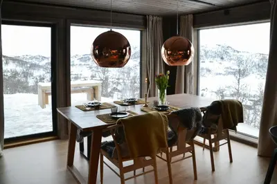 a dining room with a table and chairs and windows at Mountain Cabin By The Ski Trails In Rauland in Rauland