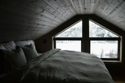 a bed in a room with a large window at Mountain Cabin By The Ski Trails In Rauland in Rauland