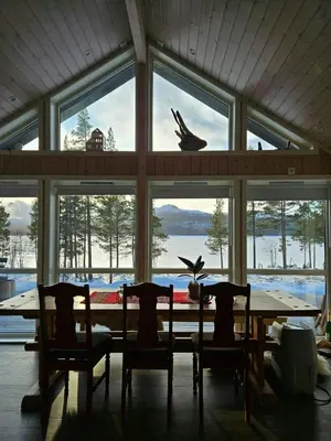 a dining room with a table and chairs and a large window at Modern Cabin With Panoramic Views Near Langedrag in Tunhovd