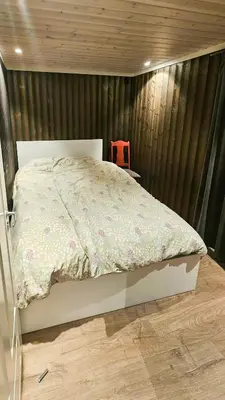 a bedroom with a bed and a red chair at Modern Cabin With Panoramic Views Near Langedrag in Tunhovd