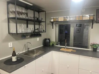a kitchen with white cabinets and a sink and a window at Trolladalen 8A1V in Sogndal