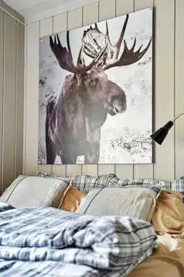 a painting of a deer on a wall above a bed at Cosy Cabin With Annex At Blefjell in Kongsberg