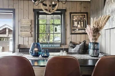 a dining room with a table with chairs and a chandelier at Cosy Cabin With Annex At Blefjell in Kongsberg