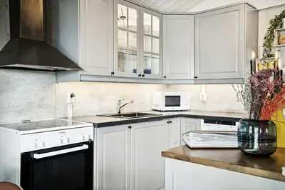 a kitchen with white cabinets and a vase of flowers at Cosy Cabin With Annex At Blefjell in Kongsberg