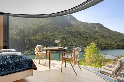 a bedroom with a table and chairs and a view of a mountain at The Sognefjord Cabin in Kaupanger
