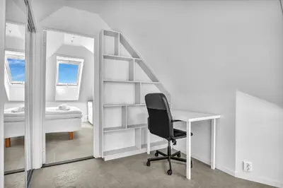 a desk and a chair in a room with a mirror at Penthouse Apartment in Bergen