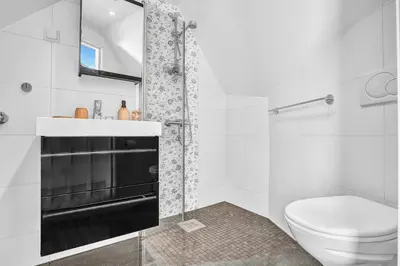 a white bathroom with a toilet and a sink at Penthouse Apartment in Bergen