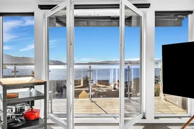 a room with large windows with a view of the ocean at Penthouse Apartment in Bergen