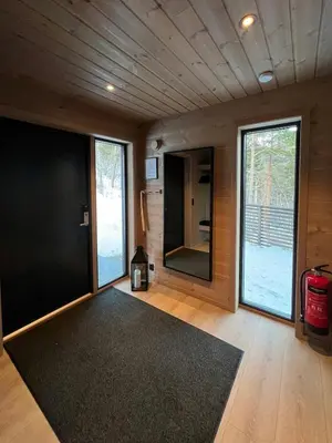 a living room with a large black rug and windows at Fjord Cabin With Panoramic Views In Rauma in Innfjorden