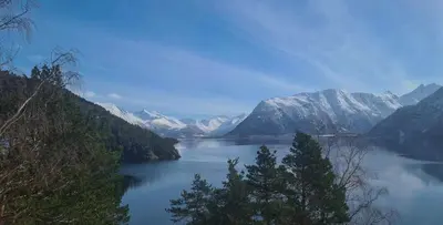a large body of water with snow covered mountains at Fjord Cabin With Panoramic Views In Rauma in Innfjorden