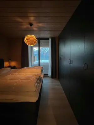 a bedroom with a bed and a chandelier at Fjord Cabin With Panoramic Views In Rauma in Innfjorden