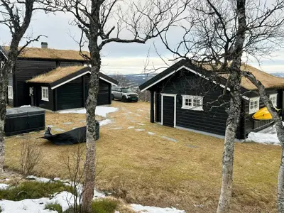 a yard with two buildings and a car parked outside at Mountain Cabin With Panoramic Views At Hummelfjell in Os
