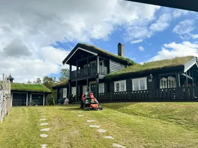 a moped parked in front of a house with a grass roof at Mountain Cabin With Panoramic Views At Hummelfjell in Os
