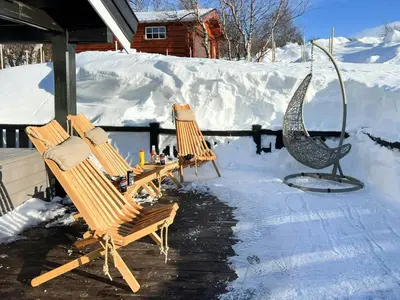 a group of chairs sitting on a porch in the snow at Mountain Cabin With Panoramic Views At Hummelfjell in Os