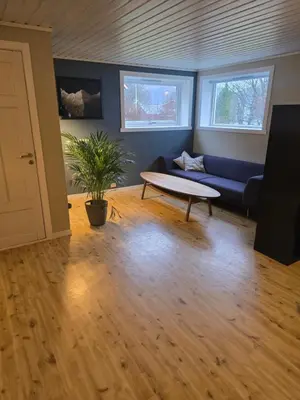 a living room with a blue couch and a table at Hagestova in Volda
