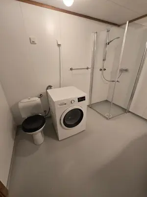 a bathroom with a washing machine and a toilet at Hagestova in Volda