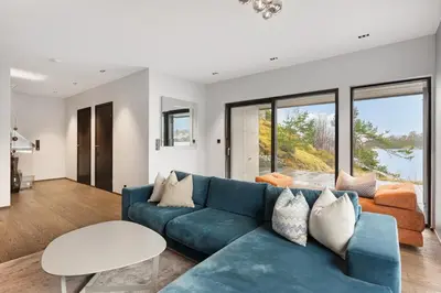 a living room with a blue couch and a table at High-End Villa with Private rooftop and sea line in Bergen