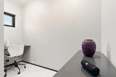 a room with a desk and a chair and a vase at High-End Villa with Private rooftop and sea line in Bergen