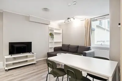 a living room with a couch and a table and chairs at Apt 500 m to Bryggen - Perfect location in Bergen