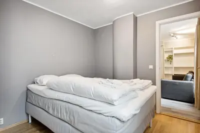 a bed with white sheets on it in a room at Apt 500 m to Bryggen - Perfect location in Bergen