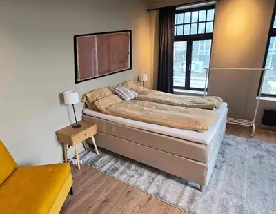 a bedroom with a bed and a tv on the wall at Oceanview Apartment Aalesund in Ålesund