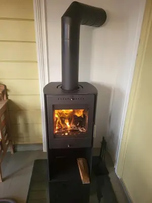 a stove in a room with a fire in it at Nygjerdet Gossen in Gossa