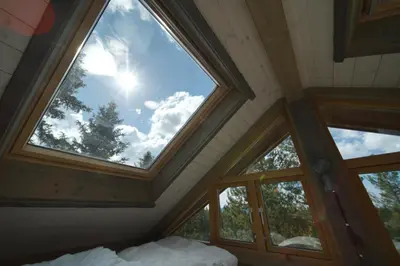 a bedroom with a large window in the ceiling at Faråsen Luxury Treetop Cabin - Sleep Among the Trees in Ringsaker