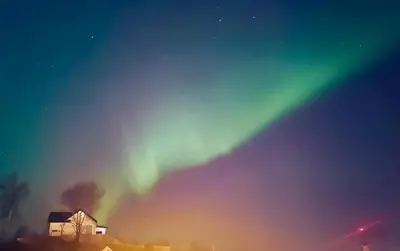 an aurora shines in the sky over a house at Hytte Hammarslandbakken in Bergen