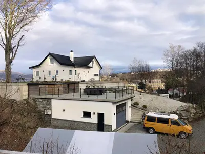 a yellow van parked in front of a white house at Hytte Hammarslandbakken in Bergen