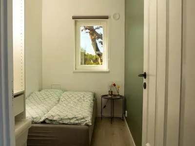 a small bedroom with a bed and a window at Hytte Hammarslandbakken in Bergen