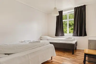 two beds in a room with a window at Trolltunga Fjord Living in Tysso